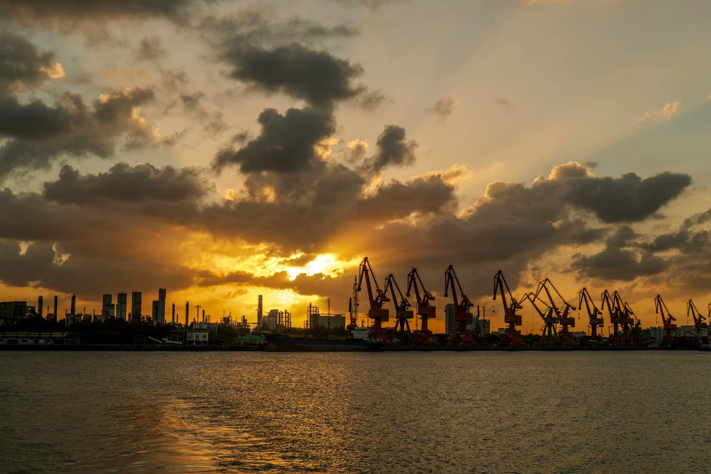 Grúas de puerto a contraluz durante el atardecer.